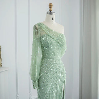 Emerald Allure: One-Shoulder Sage Green Mermaid Gown with Dubai-Inspired Gold Highlights and High Slit - A Regal Selection for Proms, Weddings, and Formal Events.