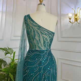 Desert Blossom: One-Shoulder Blush Pink Mermaid Evening Gown with Cape, Accented in Dubai-Inspired Emerald Green - A Luxurious Ensemble for Weddings and Grand Parties.