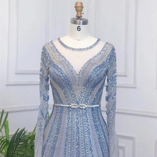 Dubai Sapphire Elegance: Luxury Blue Mermaid Evening Dress with Long Sleeves, Beaded Details, and a Belt, Ideal for Arabic Women at Wedding and Formal Parties.