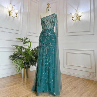 Desert Blossom: One-Shoulder Blush Pink Mermaid Evening Gown with Cape, Accented in Dubai-Inspired Emerald Green - A Luxurious Ensemble for Weddings and Grand Parties.