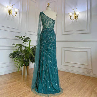 Desert Blossom: One-Shoulder Blush Pink Mermaid Evening Gown with Cape, Accented in Dubai-Inspired Emerald Green - A Luxurious Ensemble for Weddings and Grand Parties.