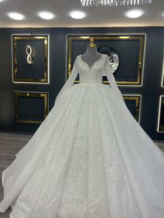 Luxurious Beaded Ball Gown Wedding Dress with Long Sheer Sleeves and Intricate Floral Embellishments