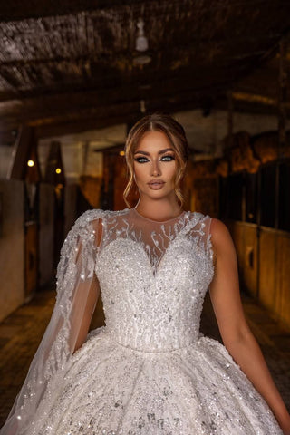 Radiant Crystal-Embellished Ball Gown Wedding Dress with Sheer Illusion Bodice and Dramatic Beaded Cape