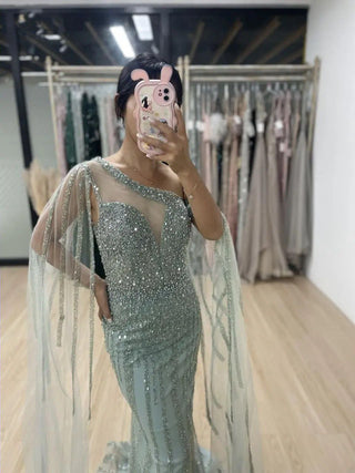 Ships in 1 to 3 Days - 2024 Green One-Shoulder Mermaid Evening Gown - Elegant Beaded Dress with Cape Sleeves for Women’s Wedding Guests and Parties